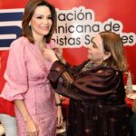 Noelia García de Pereyra recibe el pin de la ADCS, de manos de Mirna Pimentel
